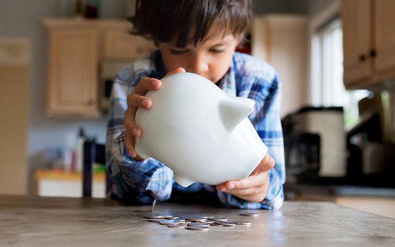 Boy emptying piggy bank